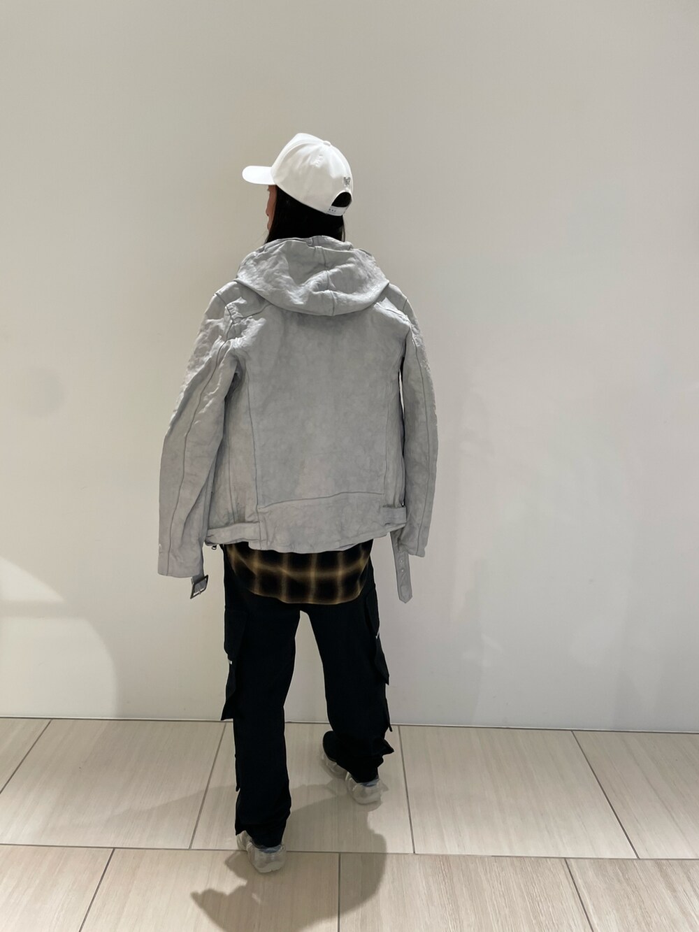 ブラック系のTシャツ/カットソー、ホワイト系のライダースジャケット、ブラック系のパンツを着用したメンズの冬コーディネートの2枚目の写真