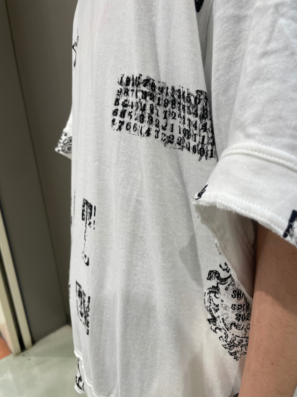 ホワイト系のTシャツ/カットソー、ブラック系のパンツ、ブラック系のスニーカーを着用したメンズの春コーディネートの4枚目の写真