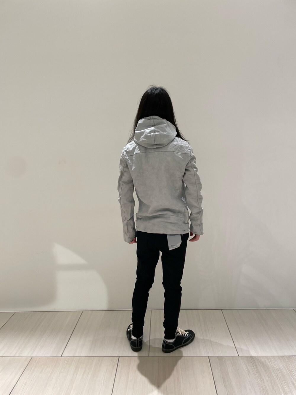 ホワイト系のジャケット/アウター、ブラック系のデニムパンツ、ブラック系のスニーカーを着用したメンズの冬コーディネートの2枚目の写真