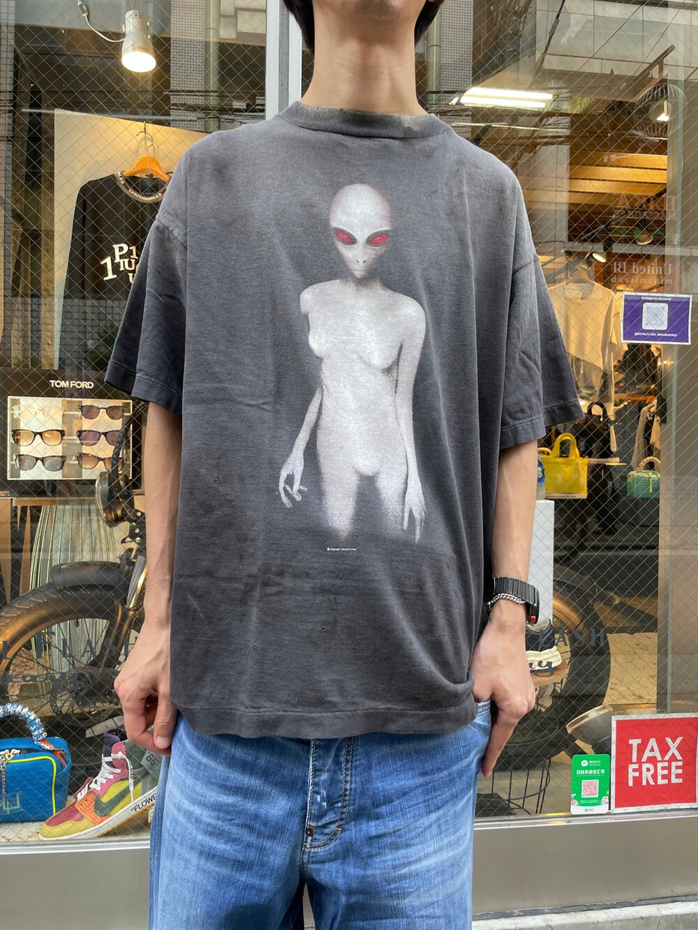 ブラック系のTシャツ/カットソー、ブルー系のデニムパンツ、ブラック系のスニーカーを着用したメンズの夏コーディネートの4枚目の写真