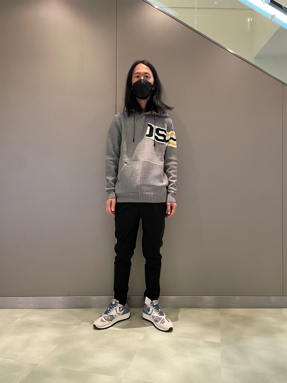 グレー系のパーカー、ブラック系のスラックス、グレー系のスニーカーを着用したメンズの夏コーディネートの3枚目の写真