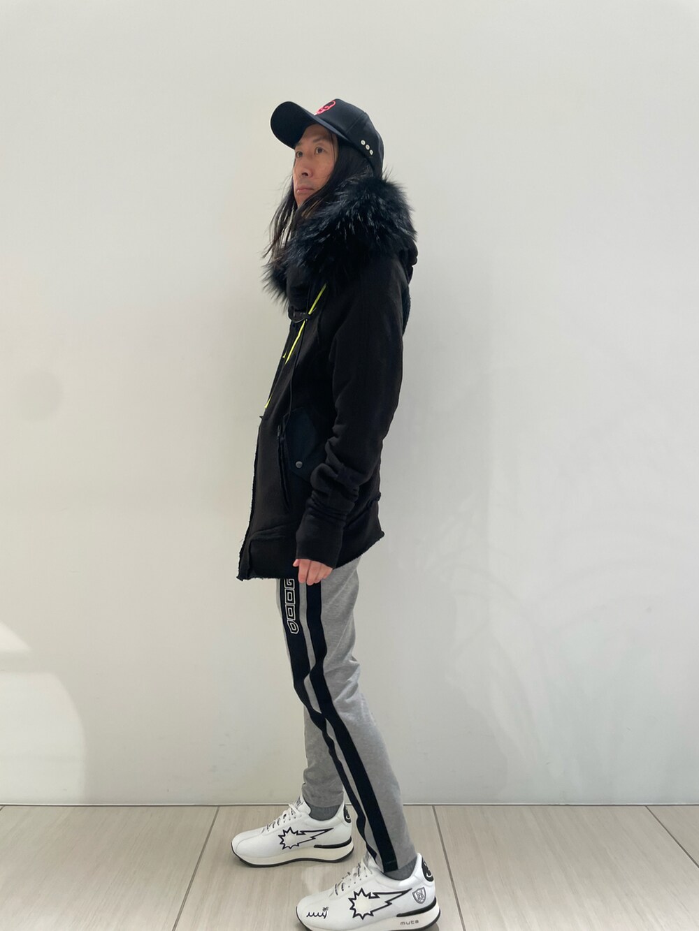 ブラック系のその他アウター、グリーン系のスウェットパンツ、ホワイト系のスニーカーを着用したメンズの冬コーディネートの2枚目の写真