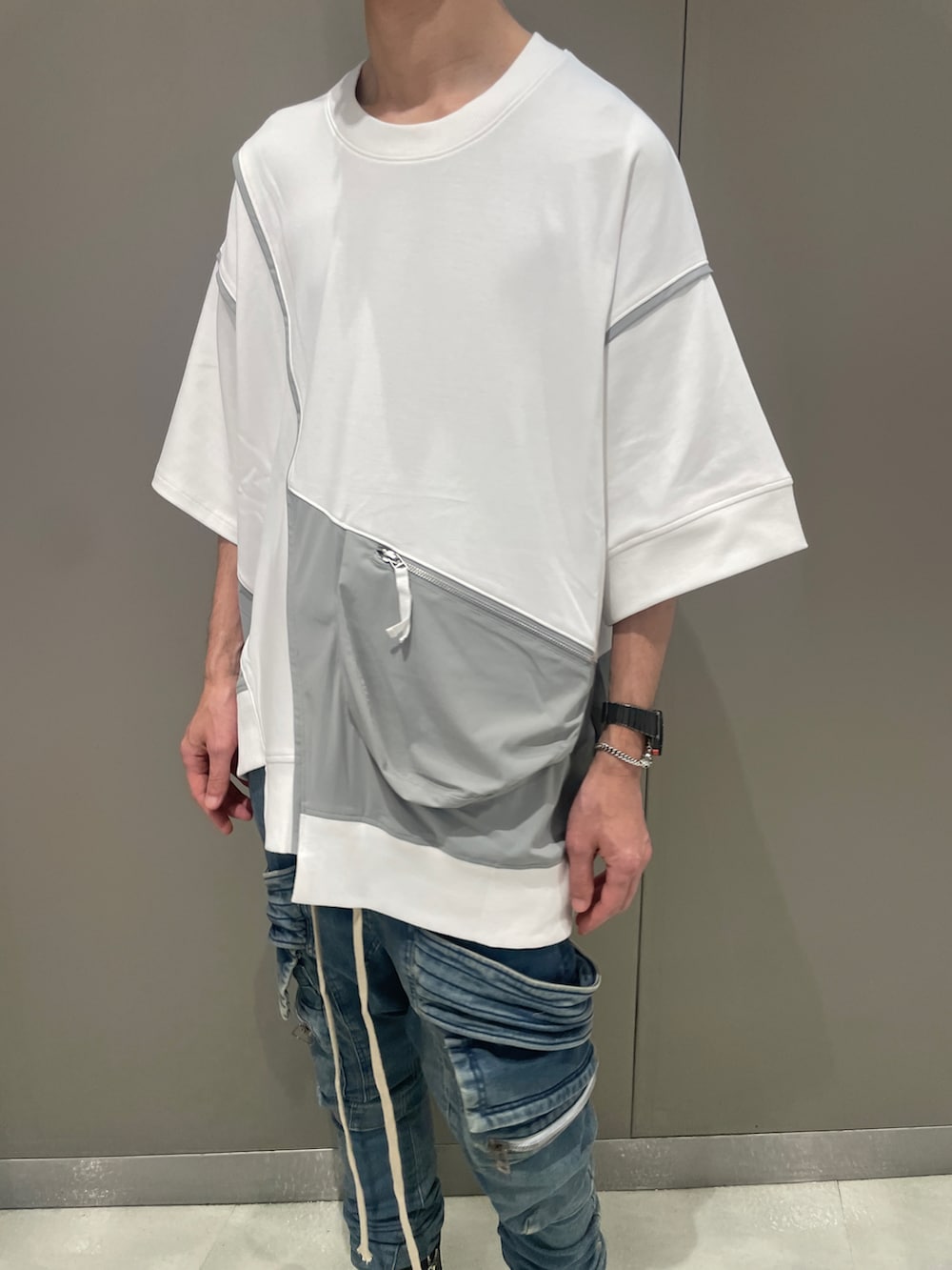 ブラック系のTシャツ/カットソー、ブルー系のデニムパンツ、ブラック系のブーツを着用したメンズの夏コーディネートの4枚目の写真