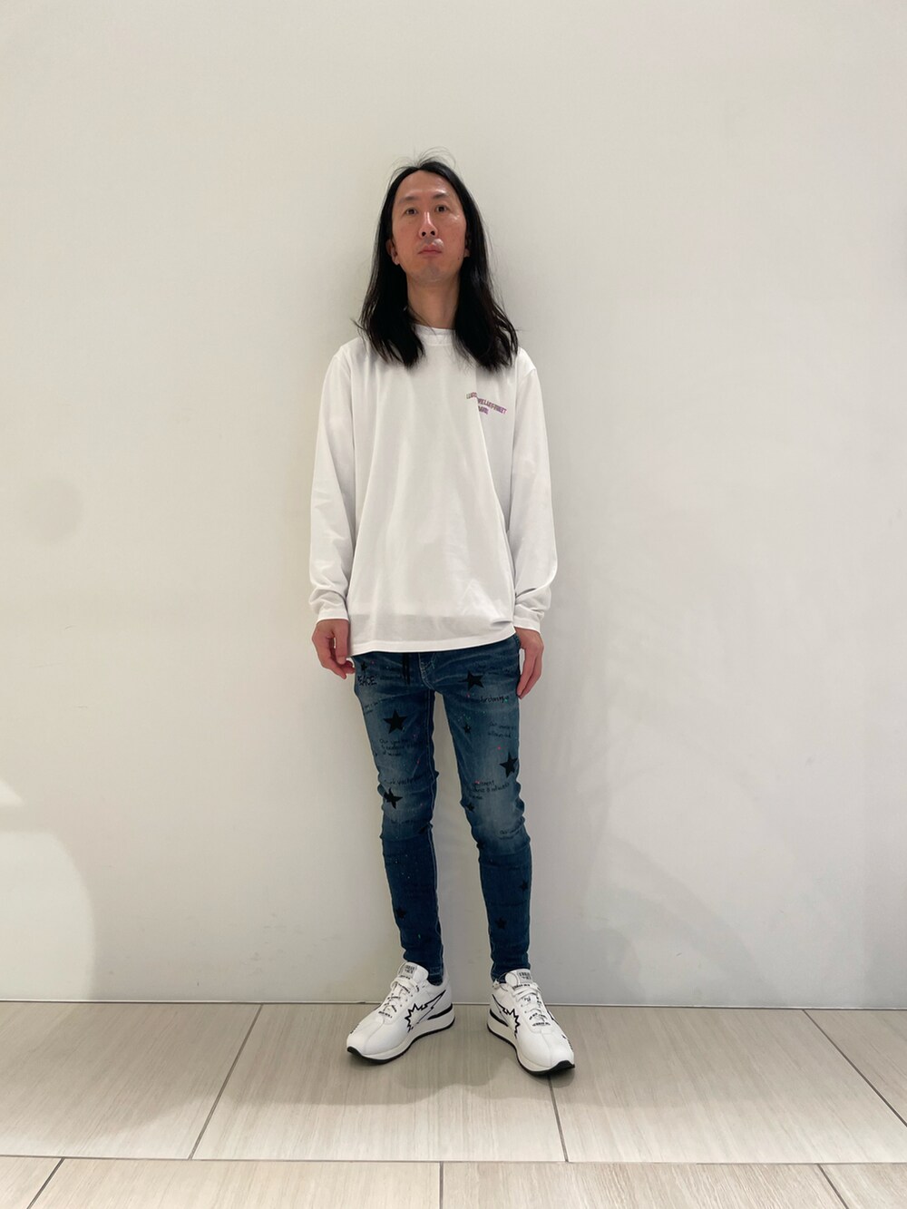 ホワイト系のTシャツ/カットソー、ブルー系のデニムパンツ、ホワイト系のスニーカーを着用したメンズの冬コーディネートの2枚目の写真