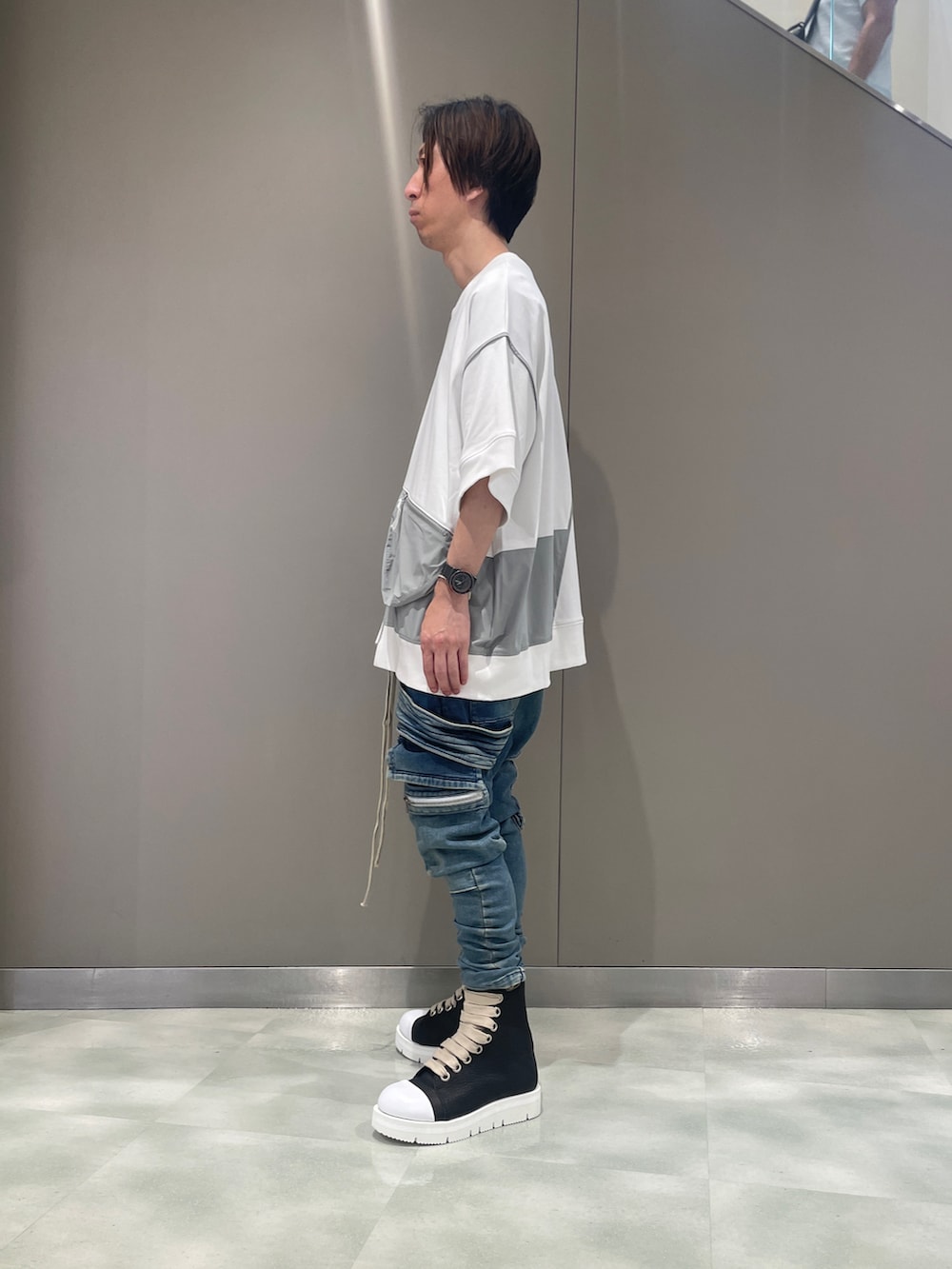 ブラック系のTシャツ/カットソー、ブルー系のデニムパンツ、ブラック系のブーツを着用したメンズの夏コーディネートの2枚目の写真