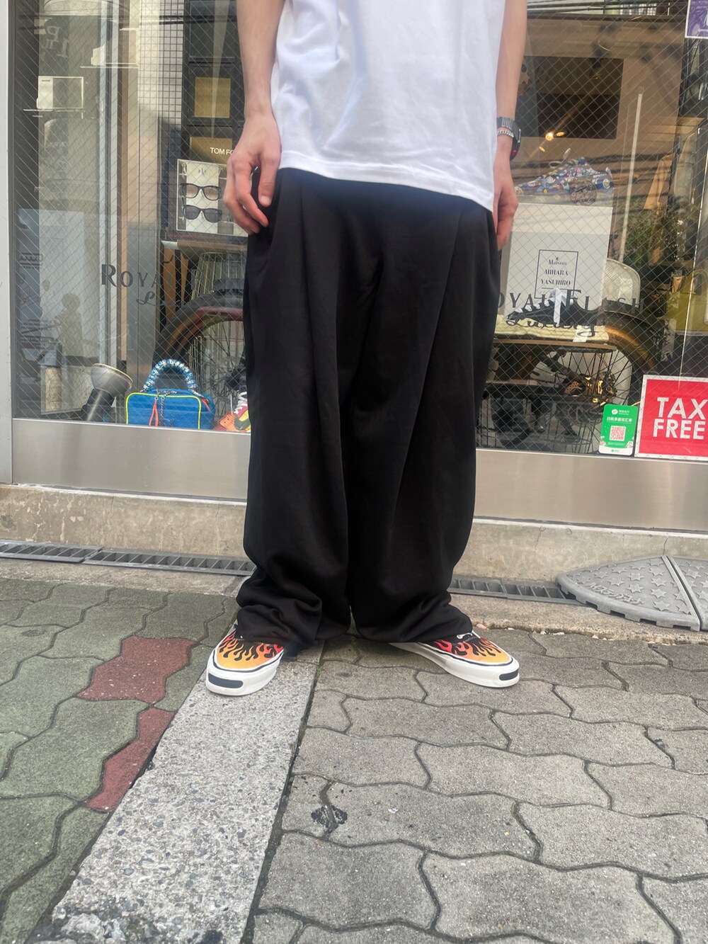 ホワイト系のTシャツ/カットソー、ブラック系のパンツ、ブラック系のスニーカーを着用したメンズの夏コーディネートの4枚目の写真