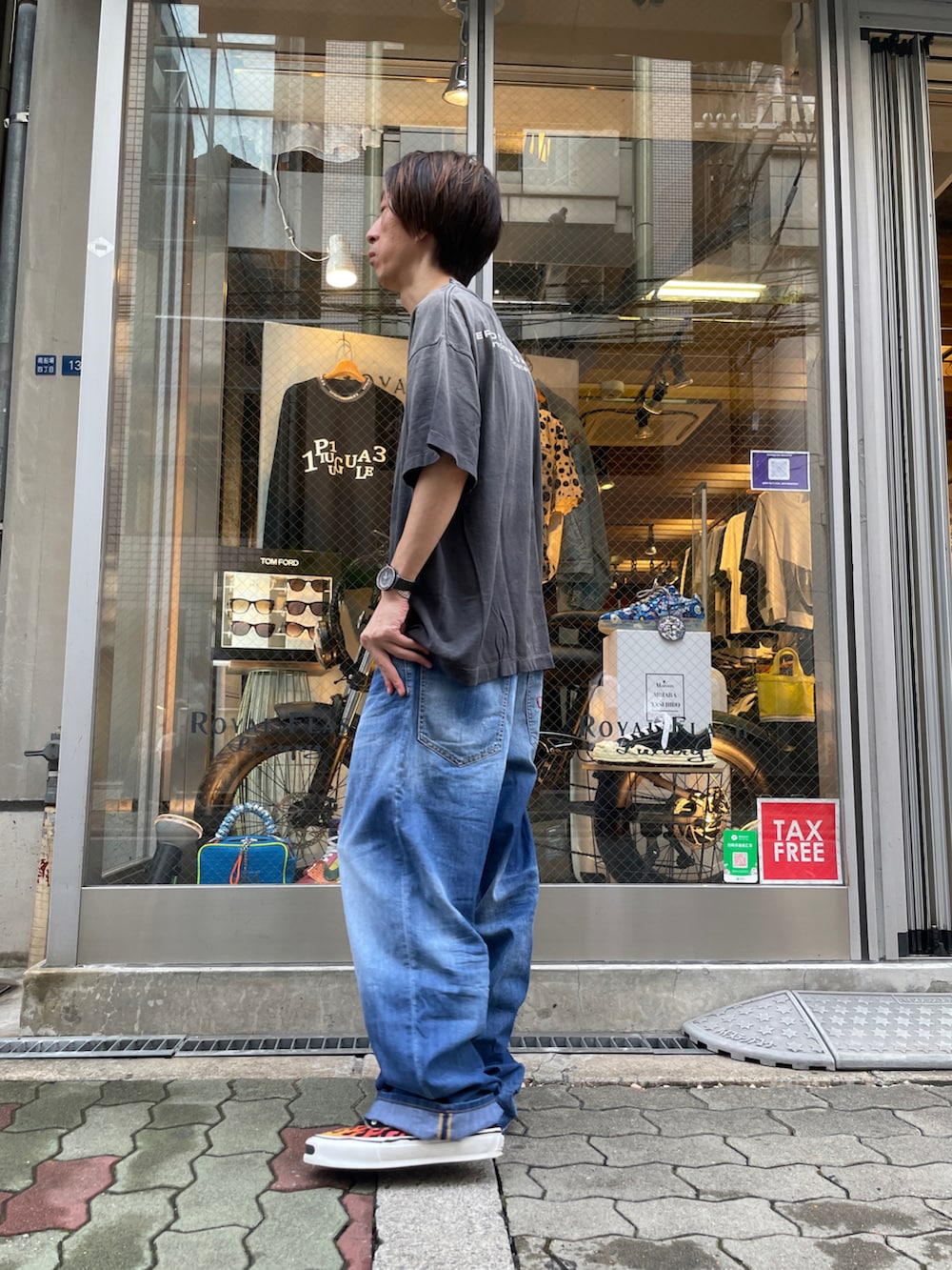 ブラック系のTシャツ/カットソー、ブルー系のデニムパンツ、ブラック系のスニーカーを着用したメンズの夏コーディネートの2枚目の写真
