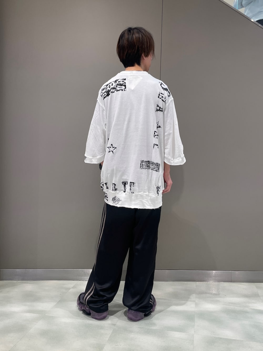 ホワイト系のTシャツ/カットソー、ブラック系のパンツ、ブラック系のスニーカーを着用したメンズの春コーディネートの2枚目の写真