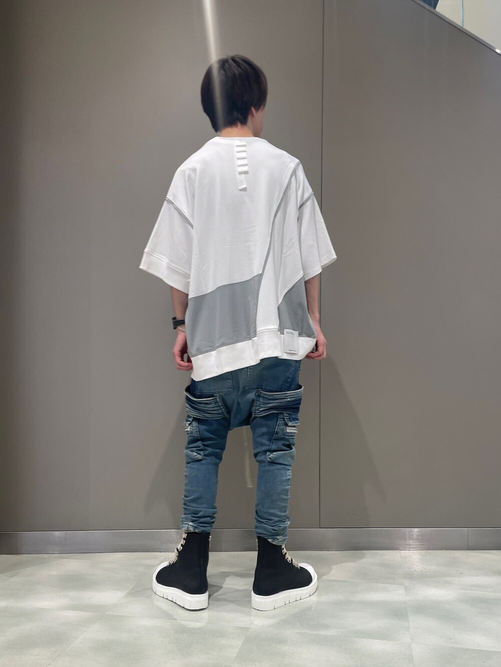 ブラック系のTシャツ/カットソー、ブルー系のデニムパンツ、ブラック系のブーツを着用したメンズの夏コーディネートの3枚目の写真