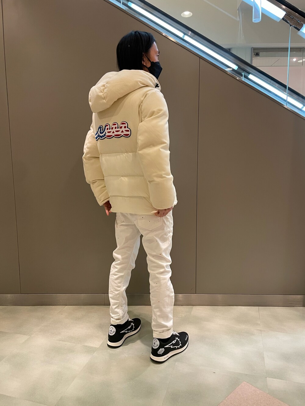 ホワイト系のデニムパンツ、ホワイト系のブルゾン、ブラック系のスニーカーを着用したメンズの秋コーディネートの2枚目の写真
