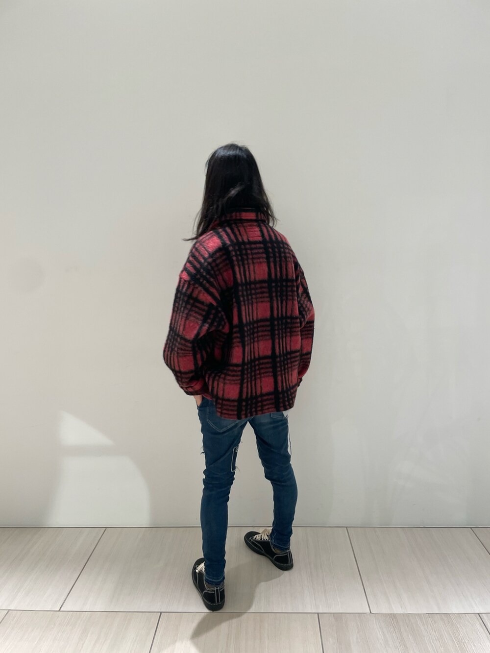 レッド系のシャツ/ブラウス、ブルー系のデニムパンツ、ブラック系のスニーカーを着用したメンズの秋コーディネートの3枚目の写真