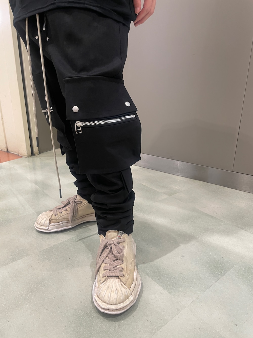 ブラック系のデニムパンツ、ブラック系のTシャツ/カットソー、ホワイト系のスニーカーを着用したメンズの春コーディネートの5枚目の写真