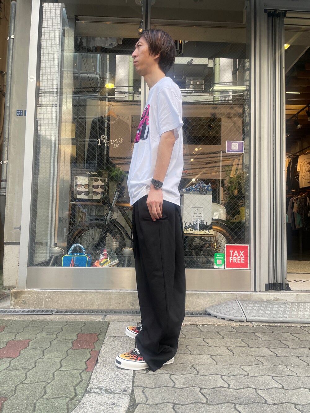 ホワイト系のTシャツ/カットソー、ブラック系のパンツ、ブラック系のスニーカーを着用したメンズの夏コーディネートの2枚目の写真