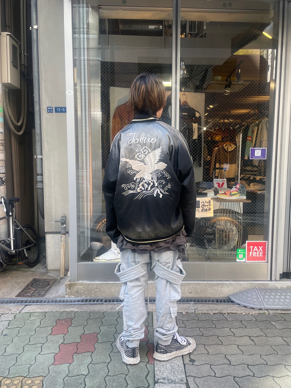 グリーン系のスカジャン、グレー系のTシャツ/カットソー、グレー系のスウェットパンツを着用したメンズの春コーディネートの3枚目の写真