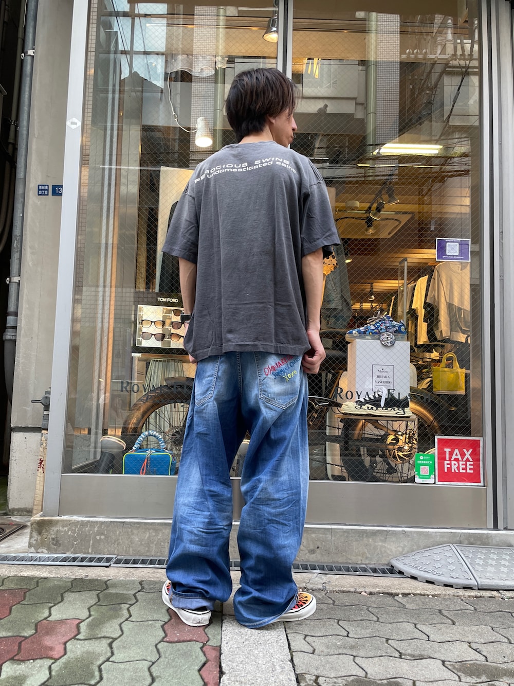 ブラック系のTシャツ/カットソー、ブルー系のデニムパンツ、ブラック系のスニーカーを着用したメンズの夏コーディネートの3枚目の写真