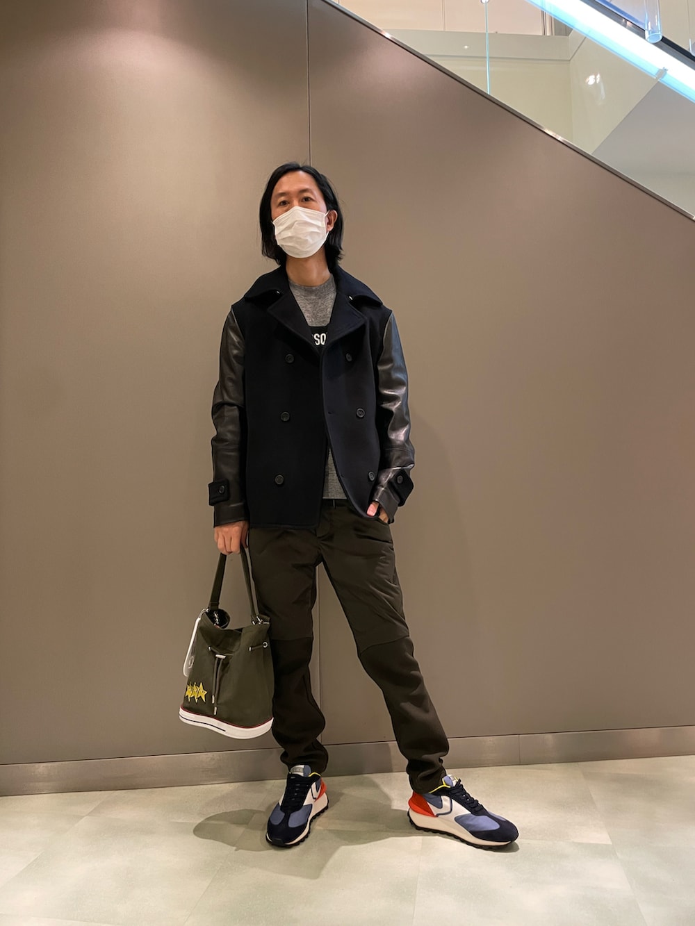 ブラック系のピーコート、グレー系のトップス、ブラック系のショルダーバッグを着用したメンズの秋コーディネートの2枚目の写真