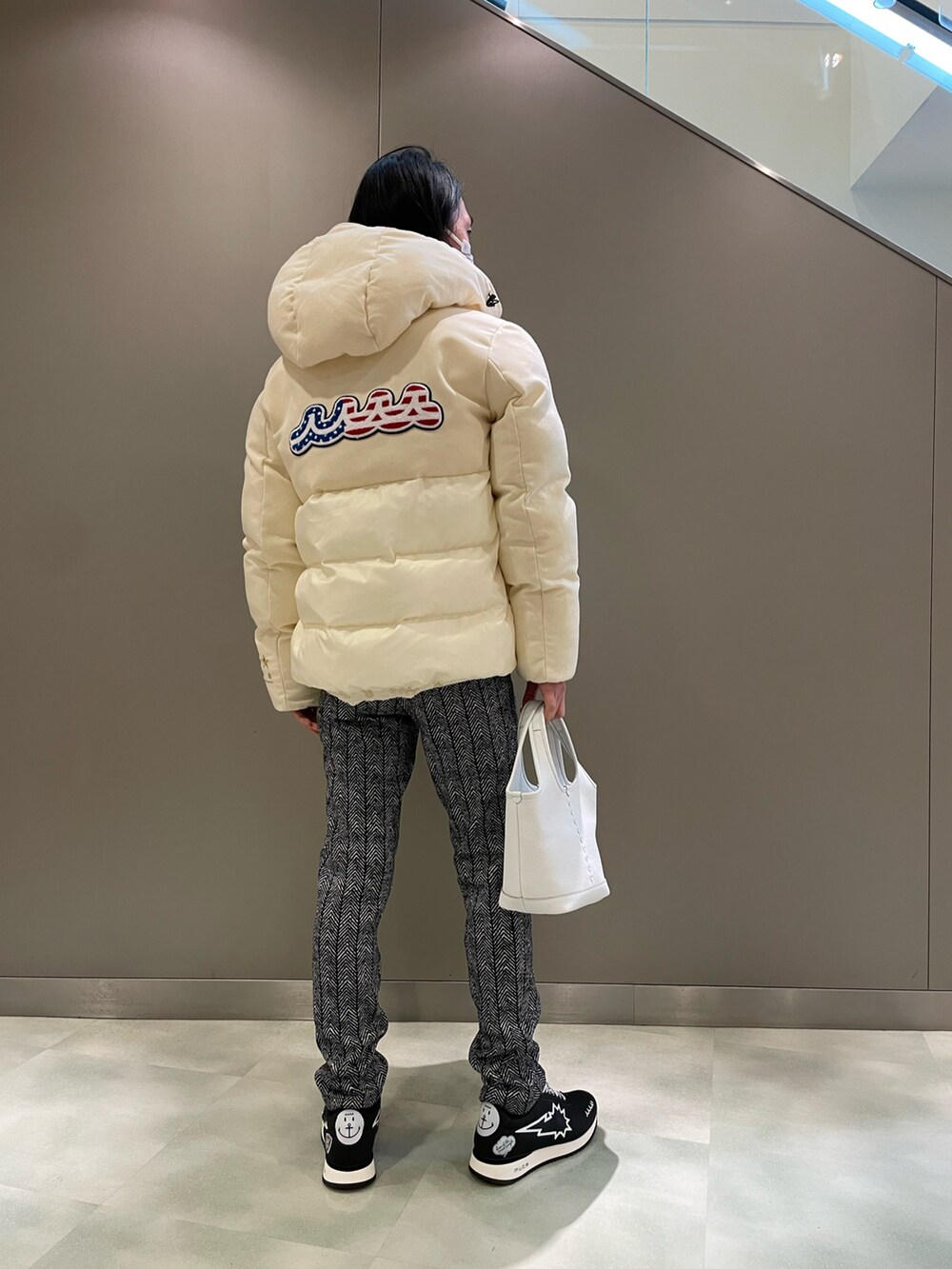 ホワイト系のパーカー、ブルー系のブルゾン、ホワイト系のトートバッグを着用したメンズの冬コーディネートの2枚目の写真