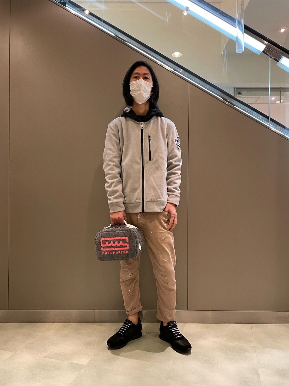 グレー系のブルゾン、グレー系のショルダーバッグ、ベージュ系のデニムパンツを着用したメンズの秋コーディネートの3枚目の写真