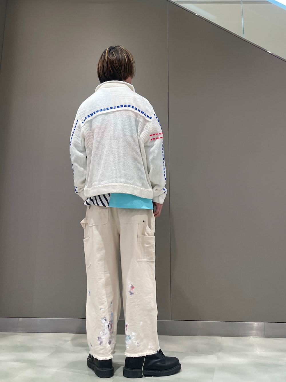 ブルー系のポロシャツ、ホワイト系のカーディガン/ボレロ、ホワイト系のパンツを着用したメンズの春コーディネートの3枚目の写真