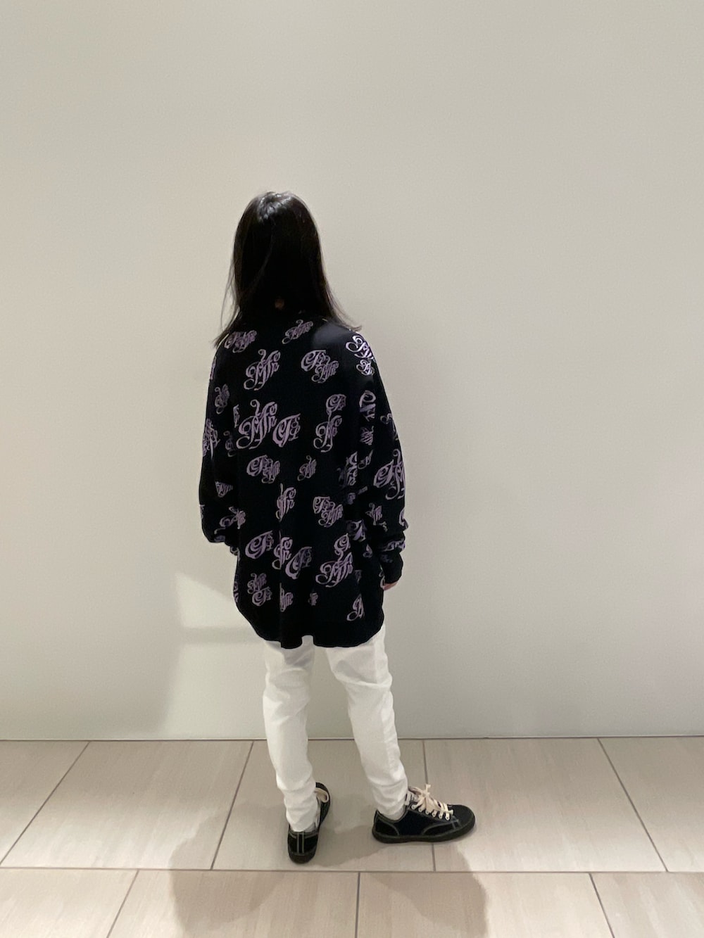 ブラック系のニット/セーター、ホワイト系のデニムパンツ、ブラック系のスニーカーを着用したメンズの秋コーディネートの2枚目の写真