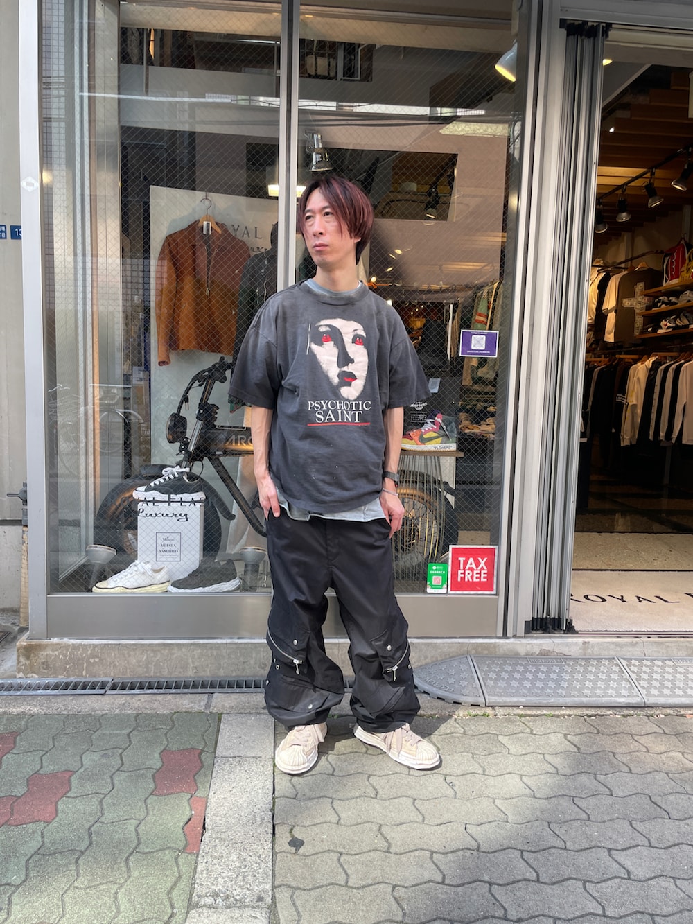 ブラック系のTシャツ/カットソー、ブラック系のカーゴパンツ、ホワイト系のスニーカーを着用したメンズの春コーディネートの2枚目の写真