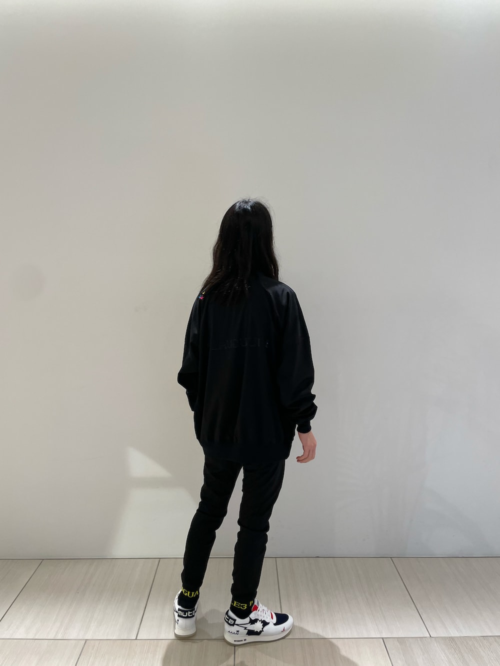 ブラック系のスウェット、イエロー系のパンツ、ホワイト系のスニーカーを着用したメンズの冬コーディネートの3枚目の写真