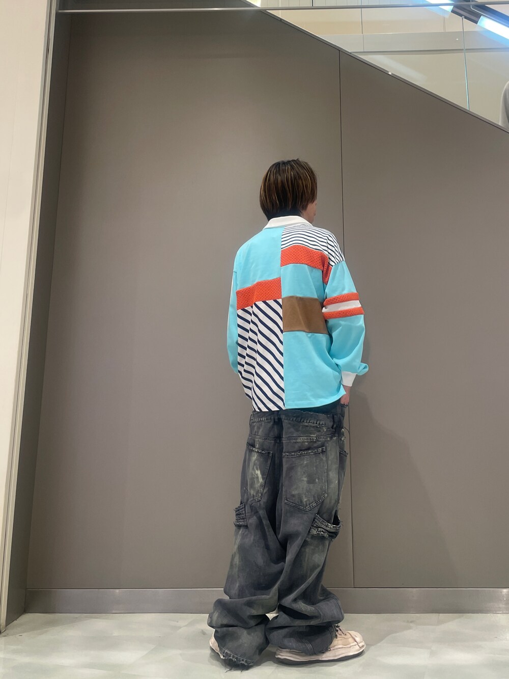 ブラック系のデニムパンツ、ブルー系のポロシャツ、ホワイト系のスニーカーを着用したメンズの春コーディネートの3枚目の写真