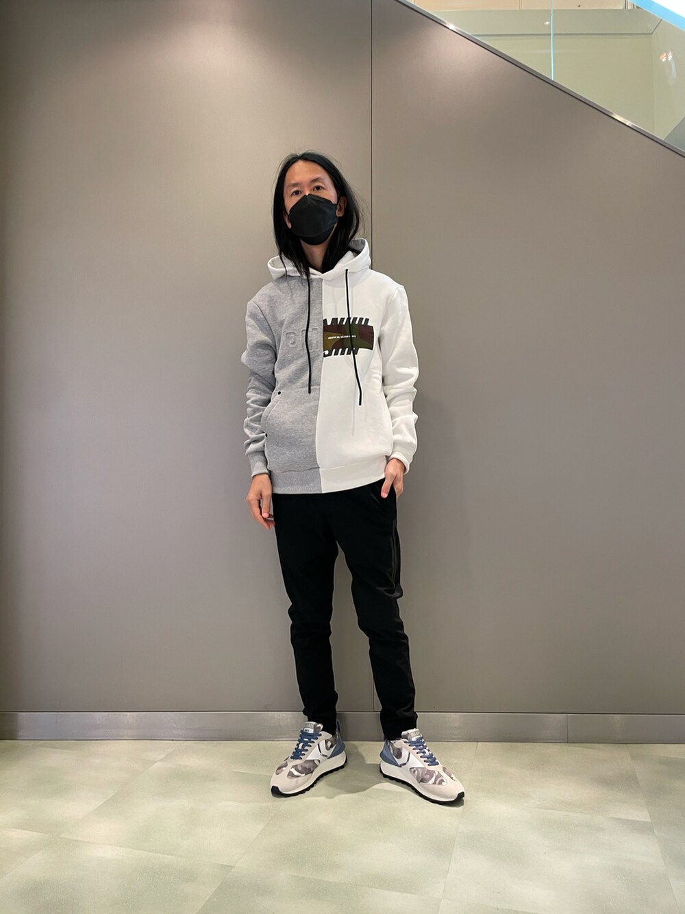 ホワイト系のパーカー、ブラック系のスラックス、グレー系のスニーカーを着用したメンズの夏コーディネートの2枚目の写真