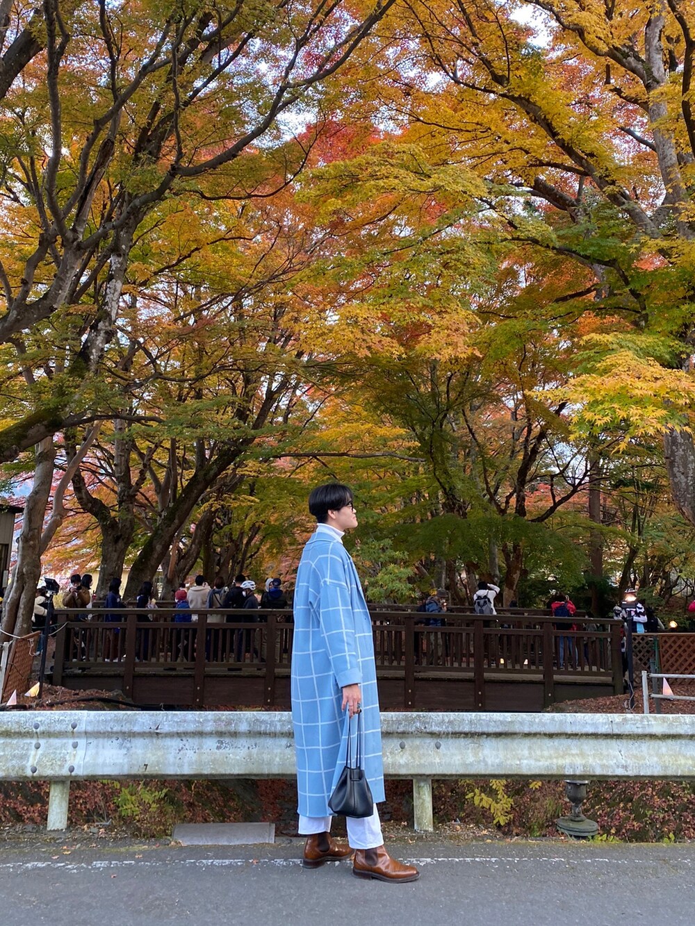 ブルー系のノーカラーコート、ホワイト系のニット/セーター、ホワイト系のデニムパンツを着用したメンズの秋コーディネートの2枚目の写真