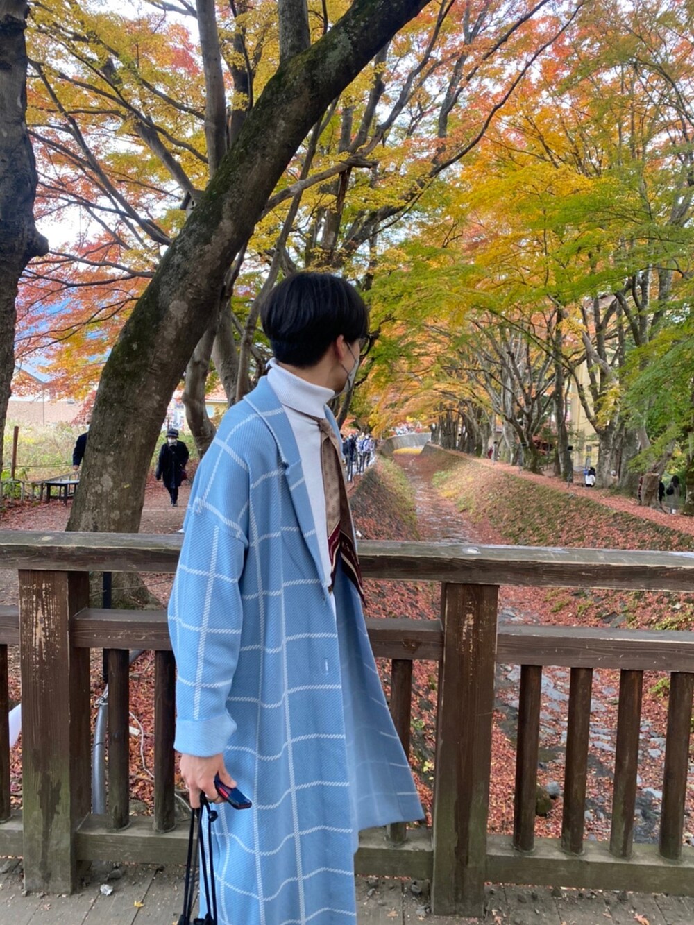 ブルー系のノーカラーコート、ホワイト系のニット/セーター、ホワイト系のデニムパンツを着用したメンズの秋コーディネートの3枚目の写真