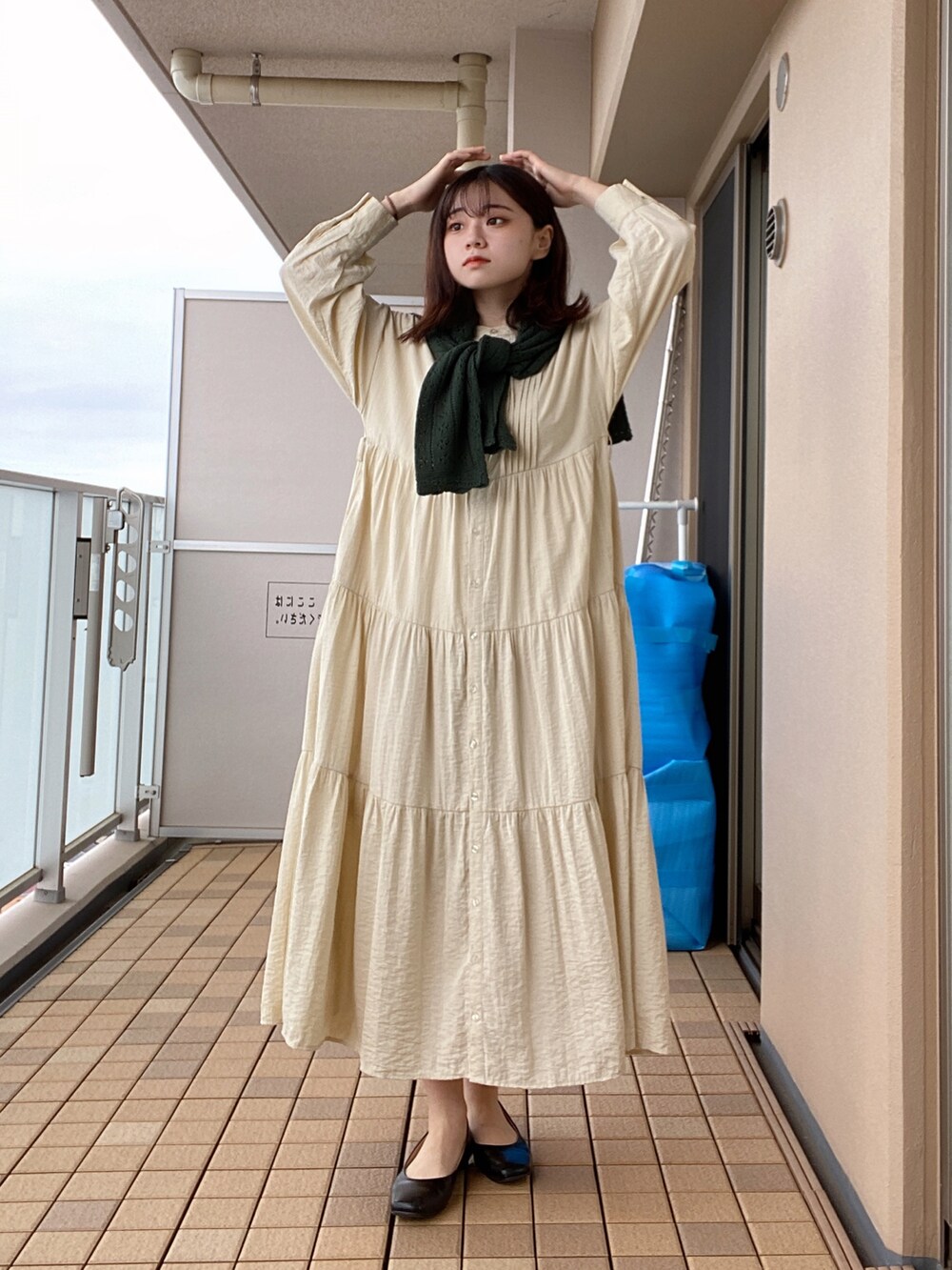 ベージュ系のシャツワンピース、グリーン系のニット/セーター、ブラック系のパンプスを着用したレディースの春コーディネートの3枚目の写真