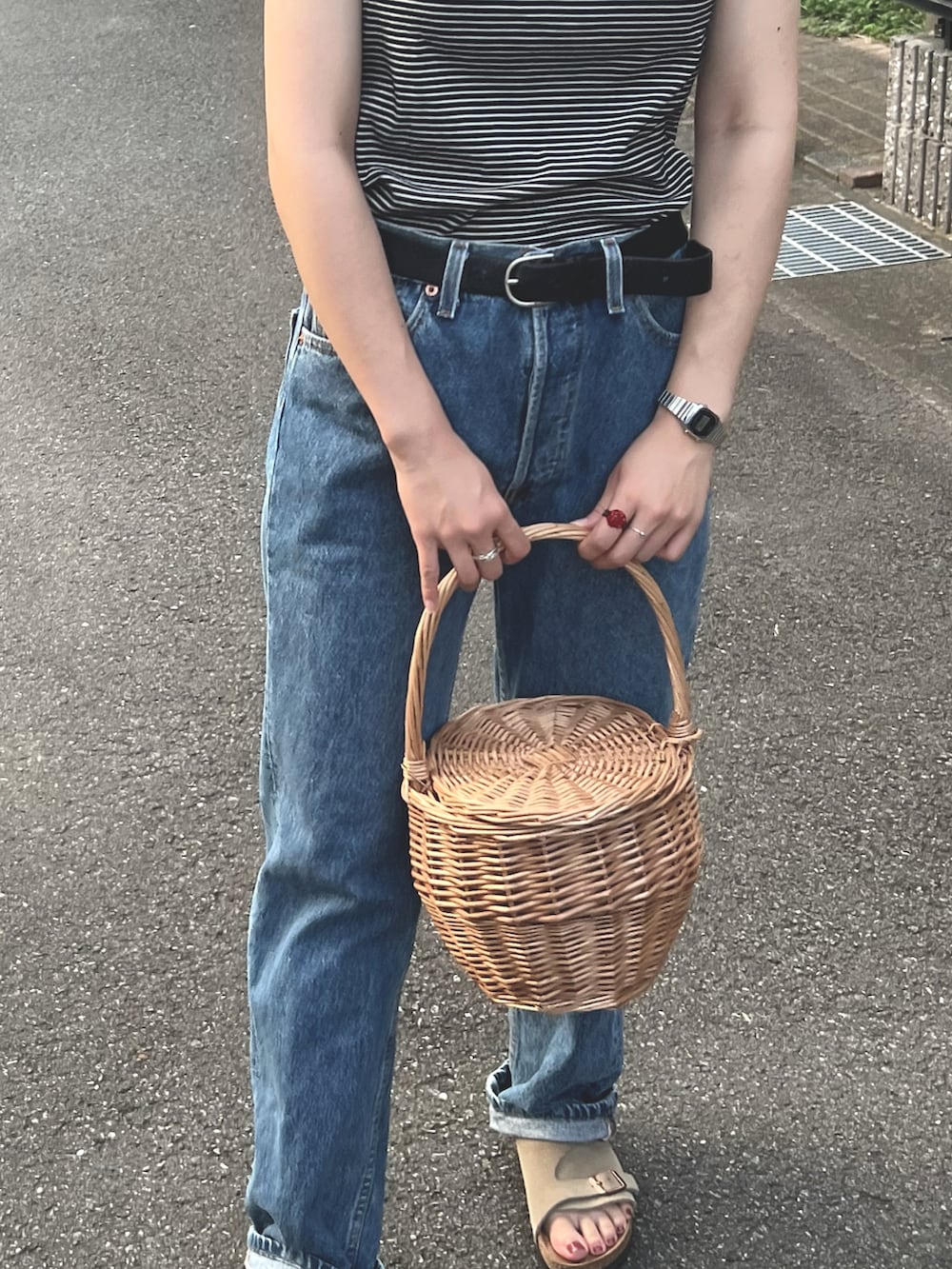 ブラック系のTシャツ/カットソー、ブルー系のデニムパンツ、ベージュ系のかごバッグを着用したレディースの夏コーディネートの2枚目の写真