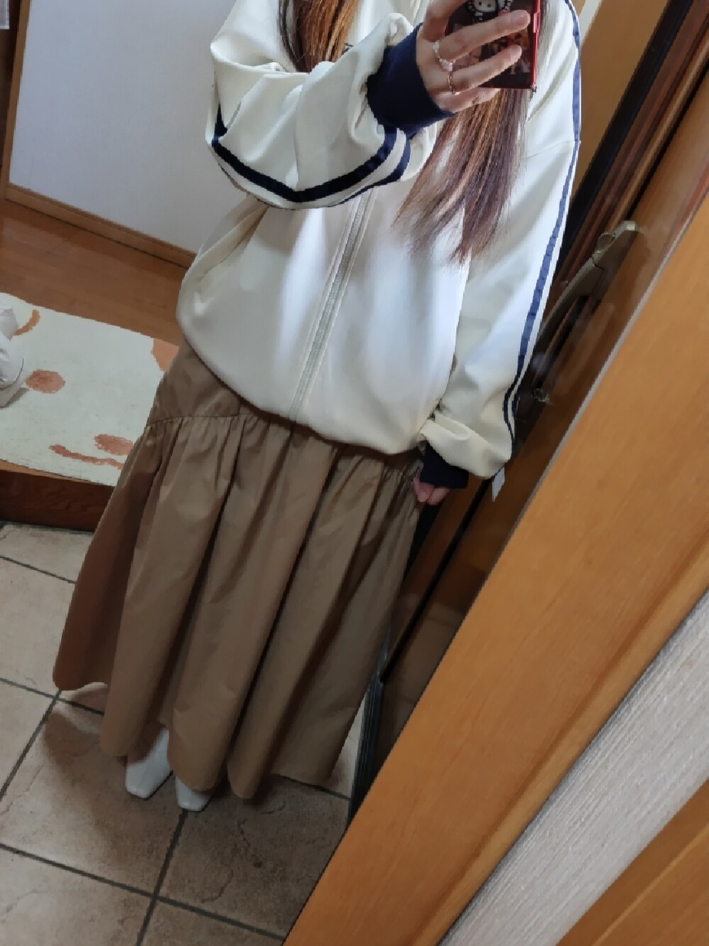 ホワイト系のスウェット、ホワイト系のショルダーバッグ、ホワイト系のダウンジャケット/コートを着用したレディースの冬コーディネートの3枚目の写真