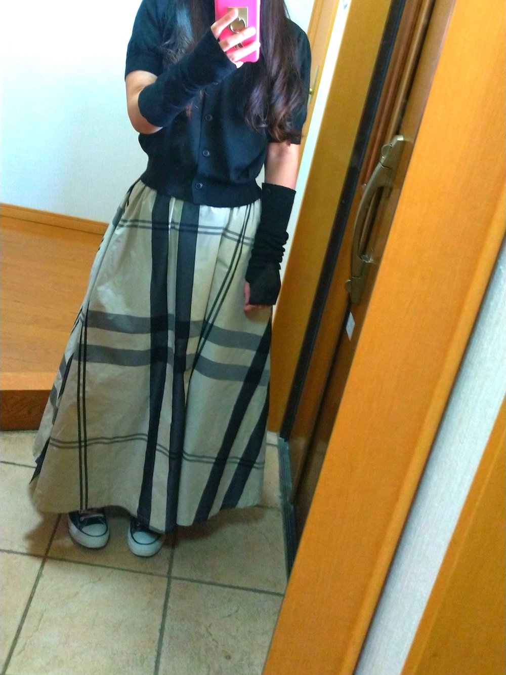 ブラック系のスニーカー、ブラック系のスカート、グリーン系のショルダーバッグを着用したレディースの秋コーディネートの2枚目の写真