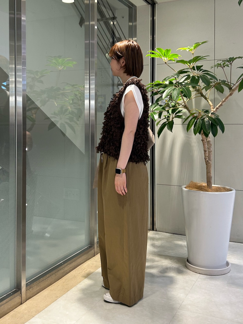 ベージュ系のデニムパンツ、ホワイト系のTシャツ/カットソー、ブラウン系のベストを着用したレディースの秋コーディネートの2枚目の写真