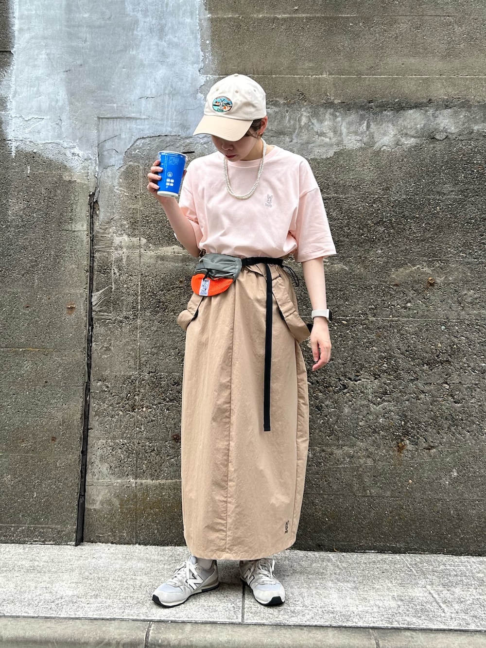 ピンク系のTシャツ/カットソー、ベージュ系のスカート、グレー系のトートバッグを着用したレディースの春コーディネートの2枚目の写真