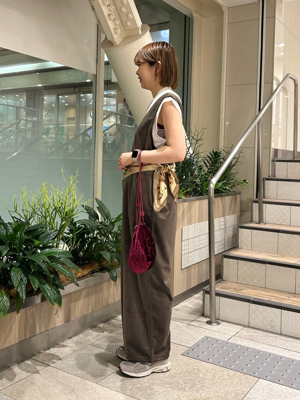 ブラウン系のつなぎ/オールインワン、ホワイト系のTシャツ/カットソー、レッド系のトートバッグを着用したレディースの秋コーディネートの2枚目の写真