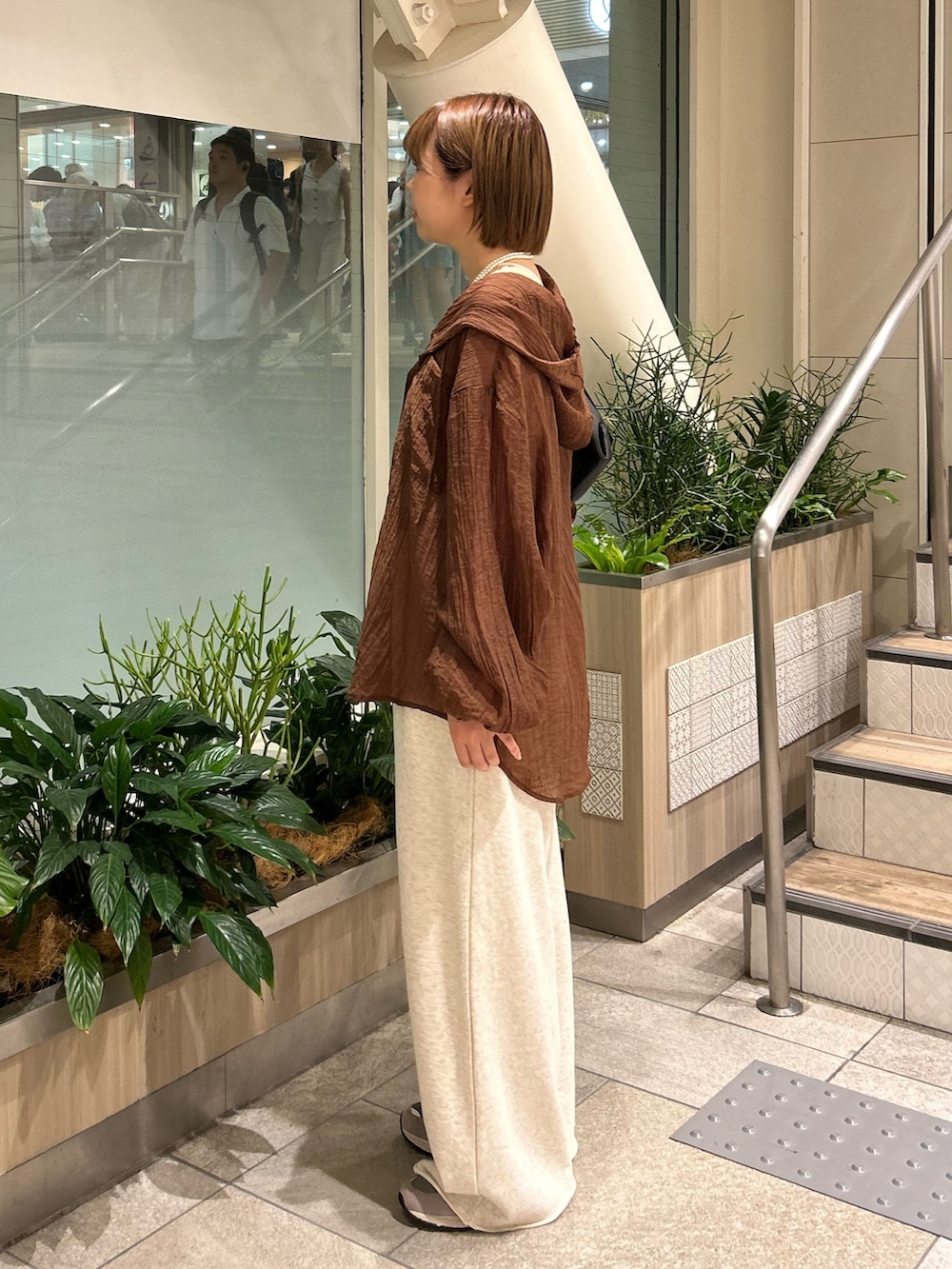 ブラック系のショルダーバッグ、ブラウン系のシャツ/ブラウス、ホワイト系のスウェットパンツを着用したレディースの夏コーディネートの3枚目の写真