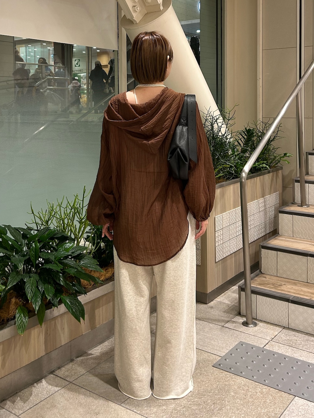 ブラック系のショルダーバッグ、ブラウン系のシャツ/ブラウス、ホワイト系のスウェットパンツを着用したレディースの夏コーディネートの4枚目の写真