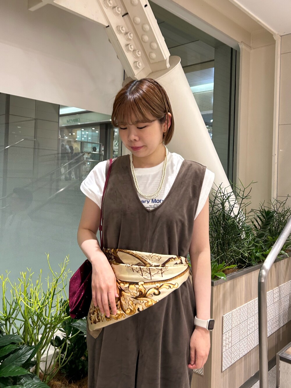 ブラウン系のつなぎ/オールインワン、ホワイト系のTシャツ/カットソー、レッド系のトートバッグを着用したレディースの秋コーディネートの4枚目の写真