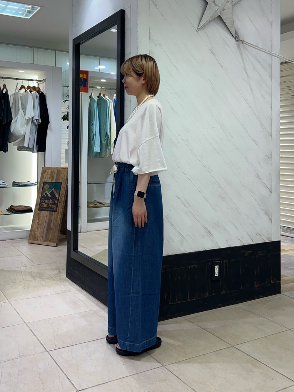 ホワイト系のTシャツ/カットソー、ブルー系のデニムパンツ、ブラック系のサンダルを着用したレディースの夏コーディネートの2枚目の写真