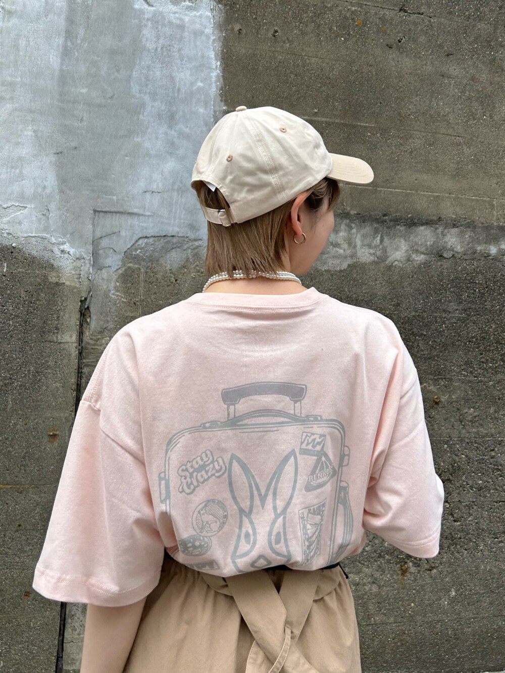 ピンク系のTシャツ/カットソー、ベージュ系のスカート、グレー系のトートバッグを着用したレディースの春コーディネートの3枚目の写真