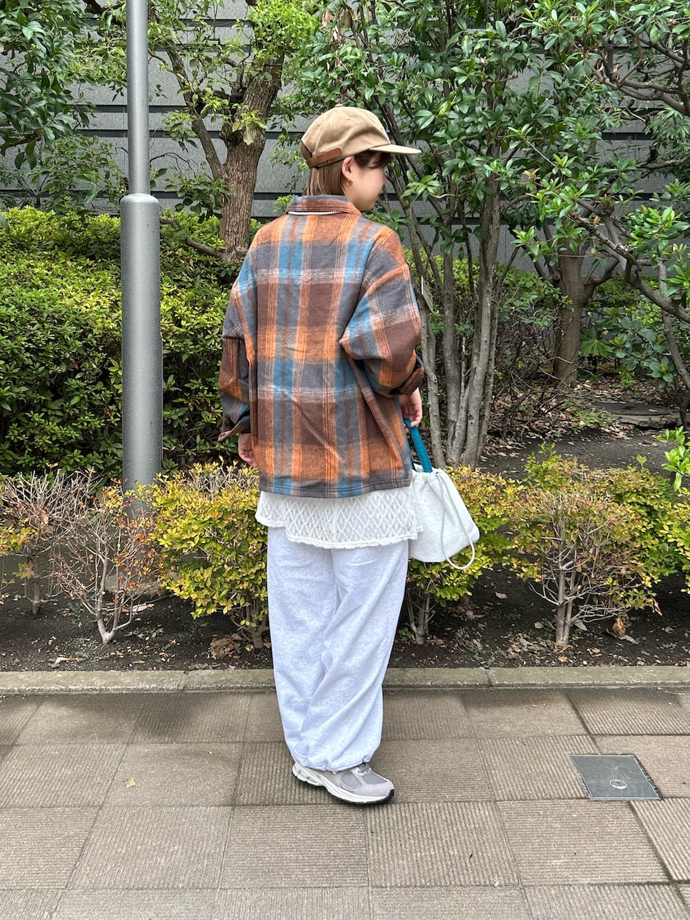 オレンジ系のシャツ/ブラウス、ホワイト系のキャミソール、グレー系のスウェットパンツを着用したレディースの秋コーディネートの2枚目の写真