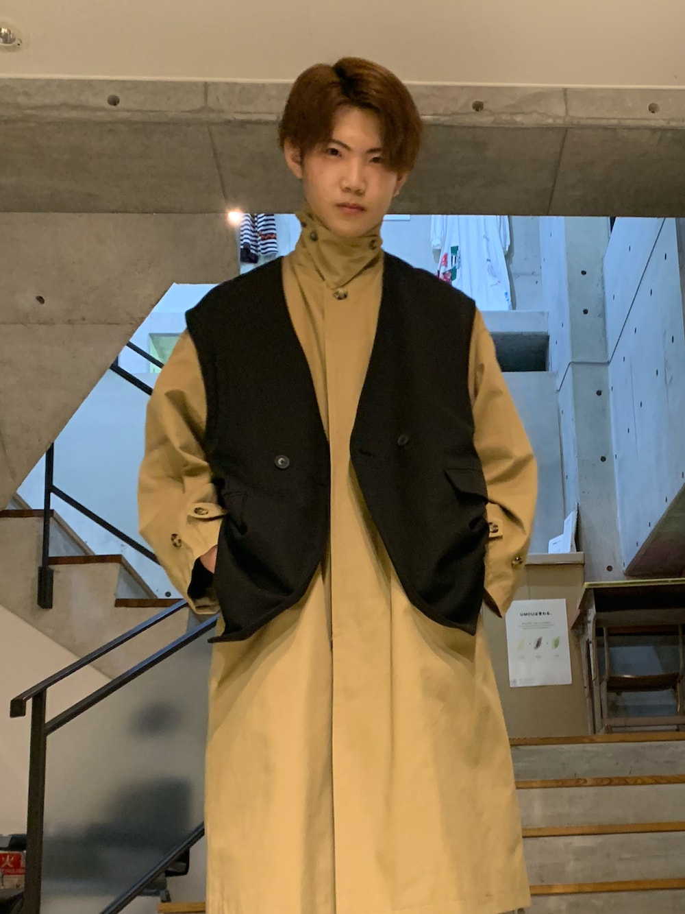 ブラック系のその他アウター、ベージュ系のステンカラーコート、ベージュ系のカーゴパンツを着用したメンズの秋コーディネートの2枚目の写真