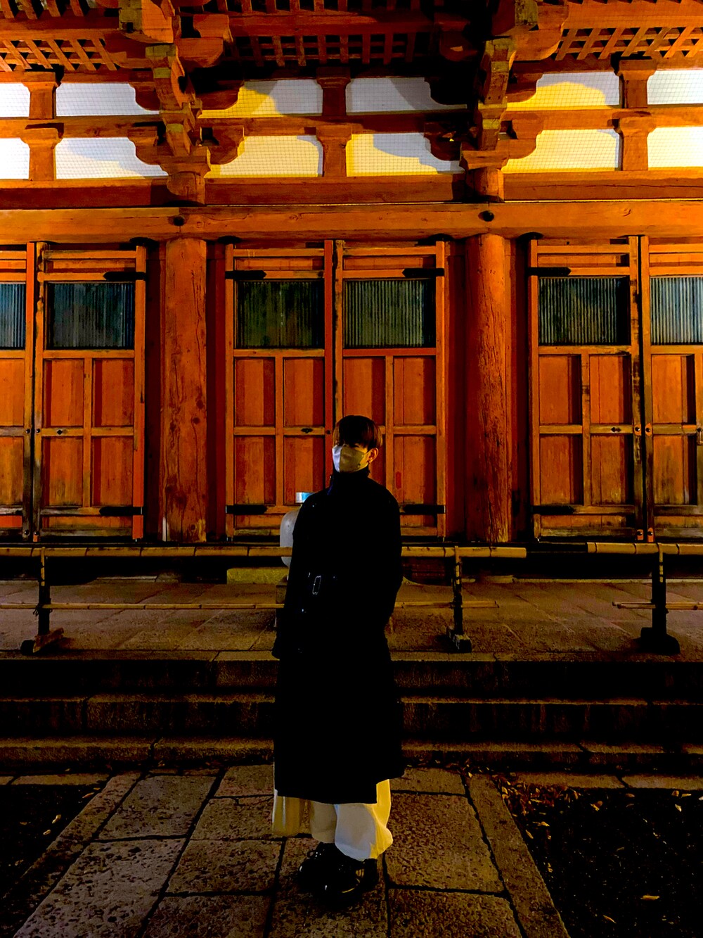 ブラック系のトレンチコート、ホワイト系のカーゴパンツ、ブラック系のスニーカーを着用したメンズの冬コーディネートの2枚目の写真