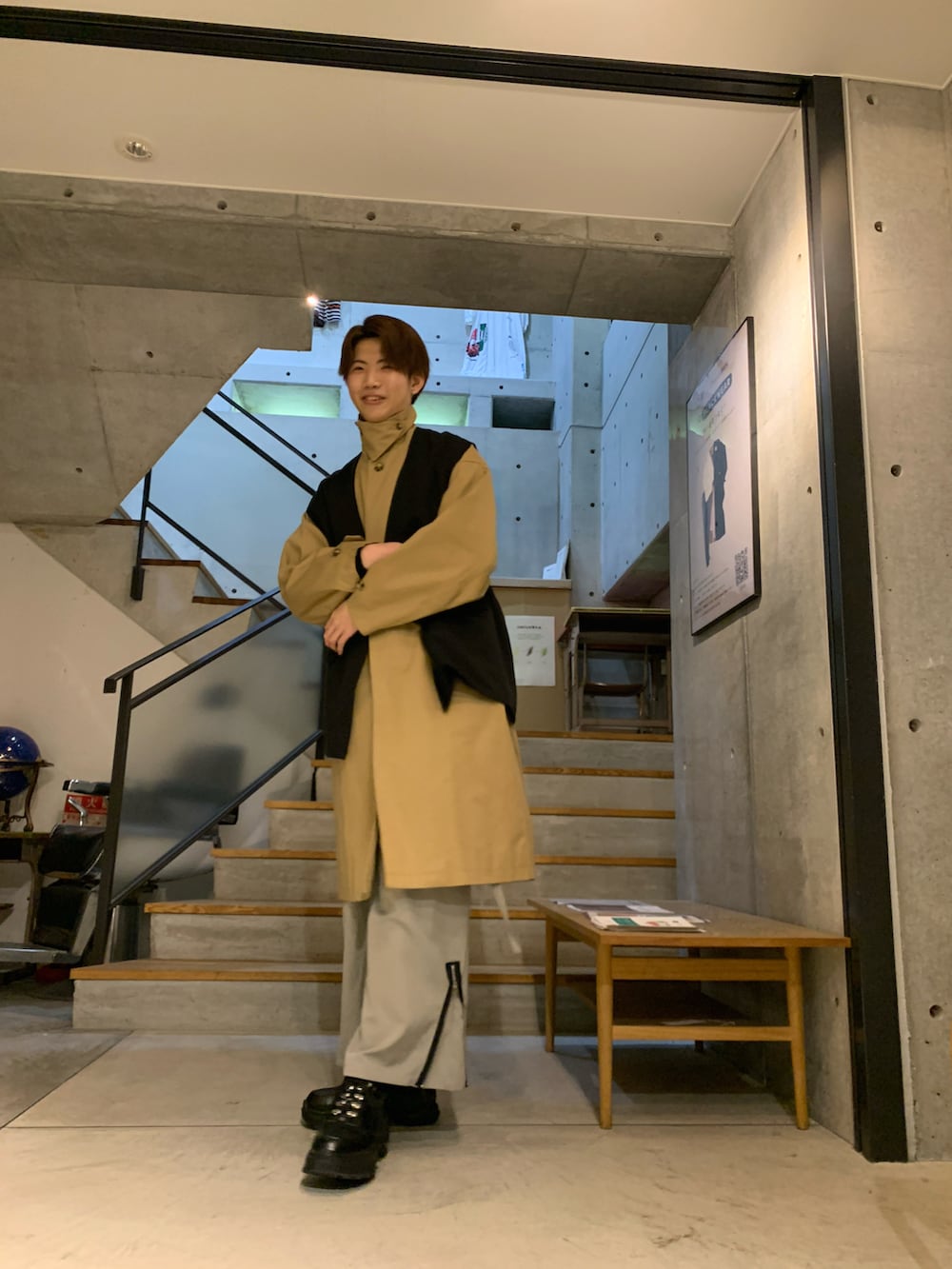 ブラック系のその他アウター、ベージュ系のステンカラーコート、ベージュ系のカーゴパンツを着用したメンズの秋コーディネートの3枚目の写真