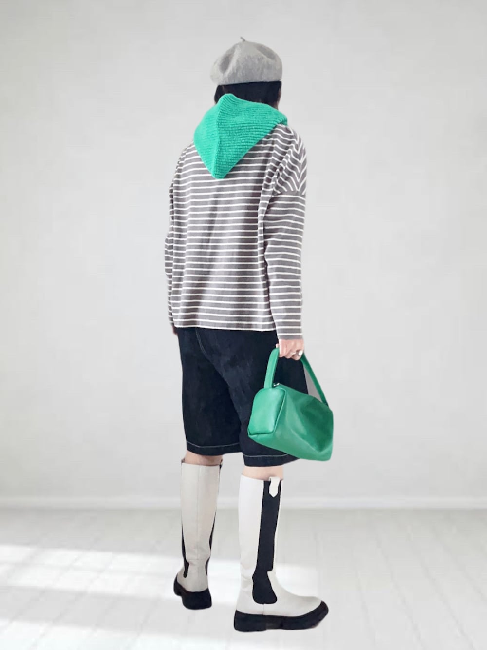 グレー系のTシャツ/カットソー、ホワイト系のブーツ、ブラック系のデニムパンツを着用したレディースの秋コーディネートの3枚目の写真