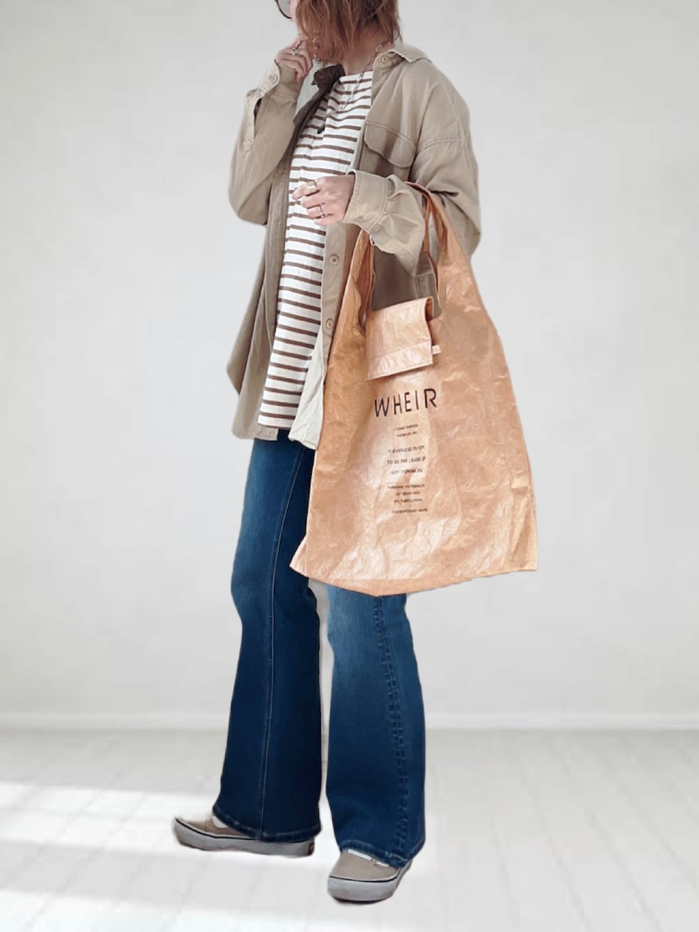 ブルー系のデニムパンツ、ブラウン系のTシャツ/カットソー、ベージュ系のシャツ/ブラウスを着用したレディースの春コーディネートの2枚目の写真