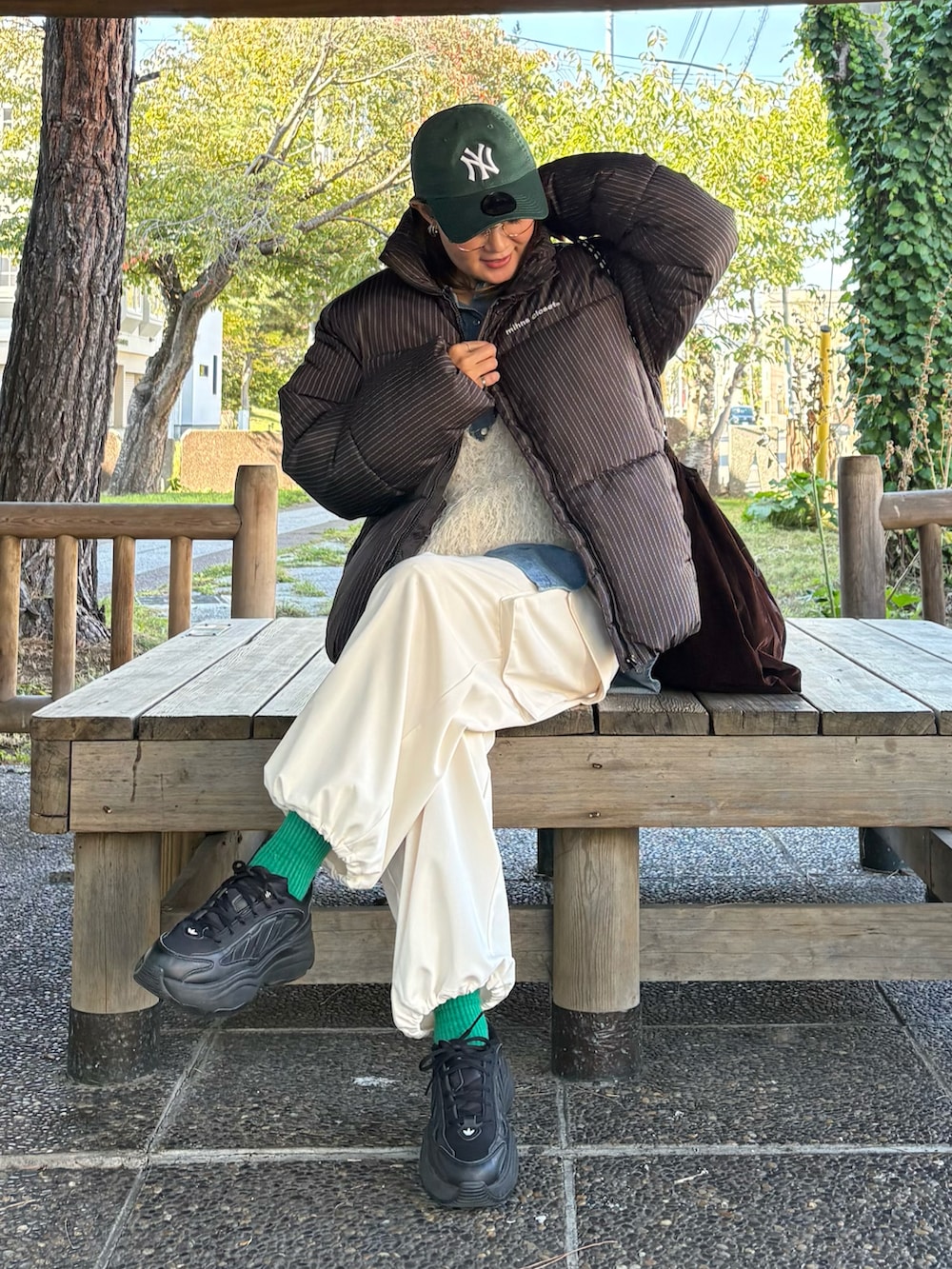 その他のダウンジャケット/コート、ブラック系のスニーカー、ブルー系のシャツ/ブラウスを着用したレディースの秋コーディネートの5枚目の写真