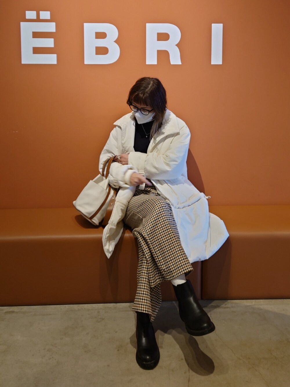 ホワイト系のその他アウター、ブラック系のニット/セーター、ベージュ系のサロペット/オーバーオールを着用したレディースの冬コーディネートの3枚目の写真